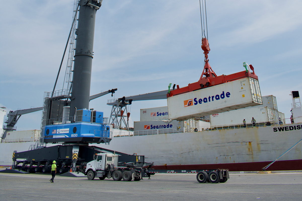 A shipping container is lifted up by one of Port Canaveral's Liebherr LHM 600 mobile harbor crane.