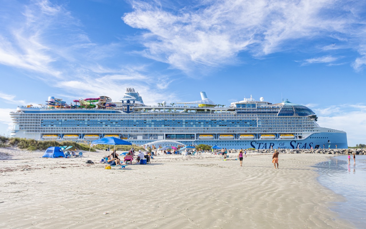 AcruiseshipsexitsPortCanaveralwhilebeachgoerswatchandplayatJettyParkbeach