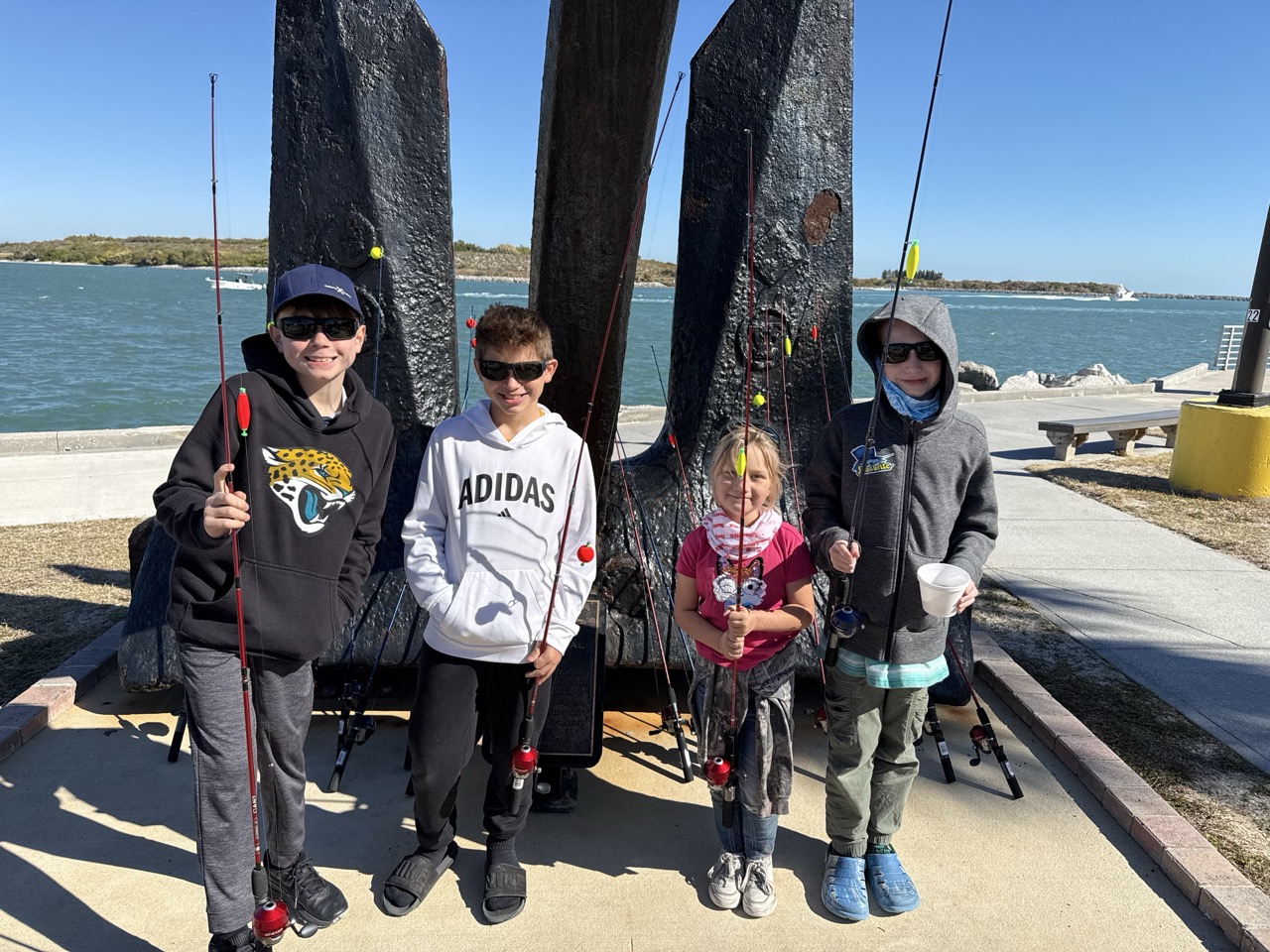 FourfishermanposeforaphotonearJettyParkspier