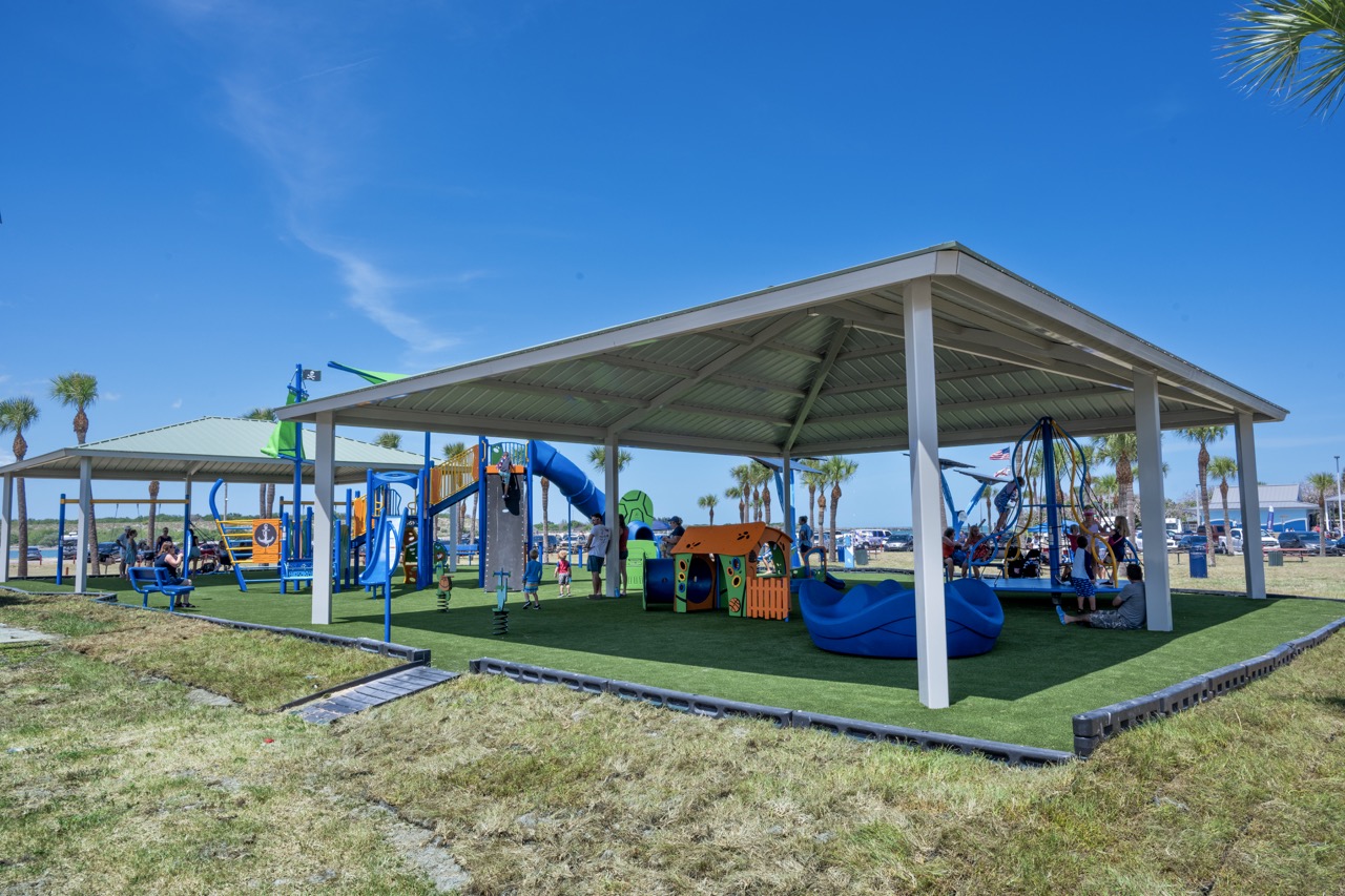 AbrandnewJettyParkplaygroundisbustlingwithfamiliesplayingonshadedequipment